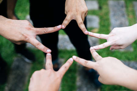 Women and men friends make star shape from fingers. Success, friendship concept.の写真素材