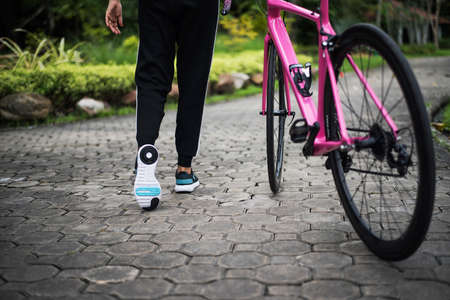 Close up of rear of woman with road bike in the park. Health and sport concept.の写真素材