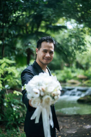 Beautiful bouquet in the hands of the groom for bride.の写真素材