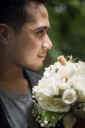 Close up of groom with beautiful bouquet in the hands for bride.の写真素材