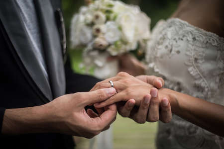 Close up of groom wears the ring bride in wedding day. Love, happy marry concept.の写真素材