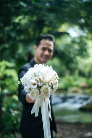 Beautiful bouquet in the hands of the groom for bride.の写真素材
