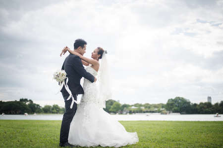Happy smiling couple in wedding. Pretty Bride and handsome groom gorgeous posting in the nature.の写真素材