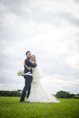 Happy smiling couple in wedding. Pretty Bride and handsome groom gorgeous posting in the nature.の写真素材