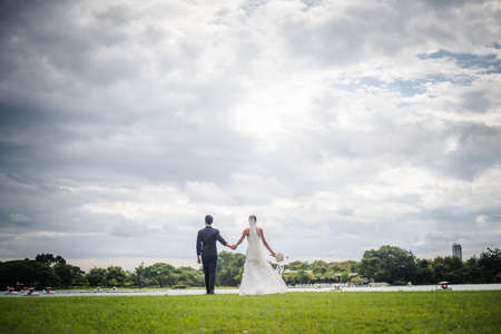 Happy smiling couple in wedding. Pretty Bride and handsome groom gorgeous posting in the nature.の写真素材