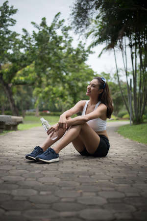 Young beautiful sport woman sit at the park after jog. Health and sport concept.の写真素材