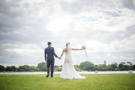 Happy smiling couple in wedding. Pretty Bride and handsome groom gorgeous posting in the nature.の写真素材