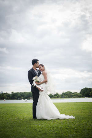 Happy smiling couple in wedding. Pretty Bride and handsome groom gorgeous posting in the nature.の写真素材
