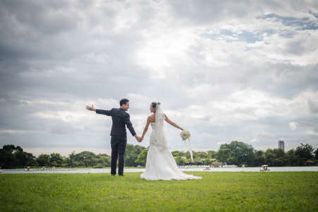Happy smiling couple in wedding. Pretty Bride and handsome groom gorgeous posting in the nature.の写真素材