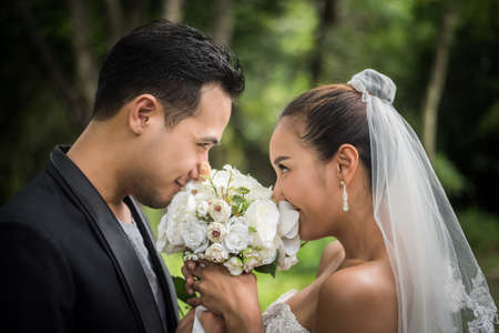 Portrait of love wedding day groom give flowers bouquet to his bride.の写真素材
