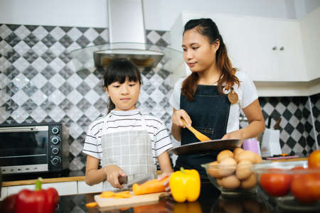 Family cooking time : Happy family help cooking meal together in kitchen at home.の写真素材