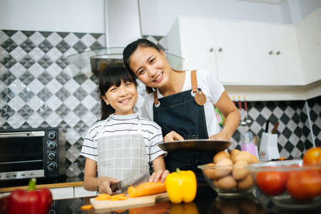 Family cooking time : Happy family help cooking meal together in kitchen at home.の写真素材