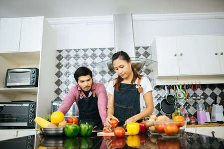 Happy couple cooking together in the kitchen at home. Couple conceptの写真素材