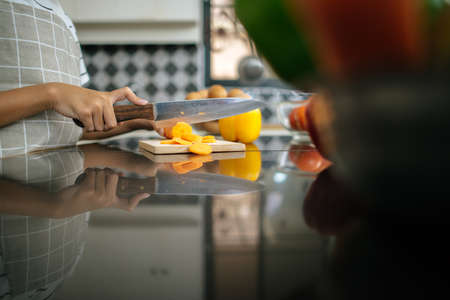 Close up of girl hand chopping carrot preparing for cook.の写真素材