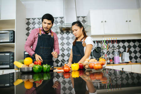 Happy couple cooking together in the kitchen at home. Couple conceptの写真素材