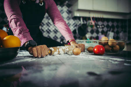 Man kneading homemade pizza dough in the kitchen. Cooking concept.