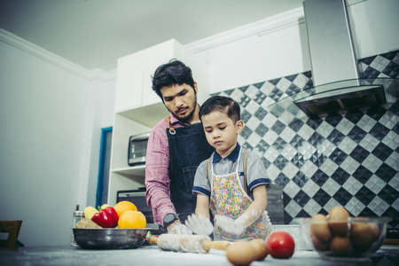 Dad teach his son how to cook in kitchen at home. Family concept.の写真素材
