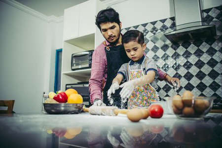 Dad teach his son how to cook in kitchen at home. Family concept.の写真素材