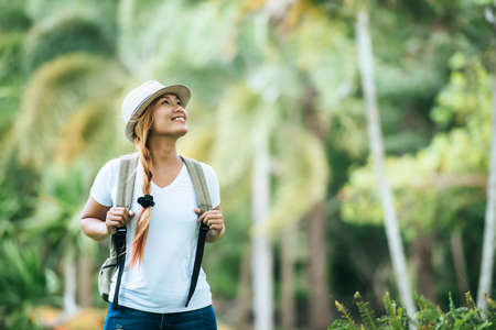 Young tourist woman with backpack enjoy nature looking away. Woman travel concept.の写真素材