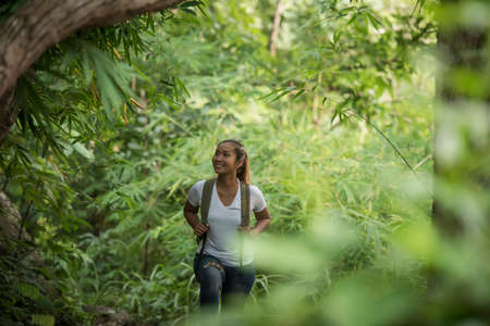 Close up of young backpacker walking through the forest happy with nature. Travel concept.の写真素材