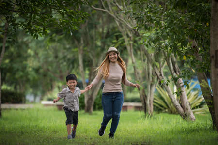 Portrait of mother and son happy walking together in the park holding hand. Family concept.の写真素材