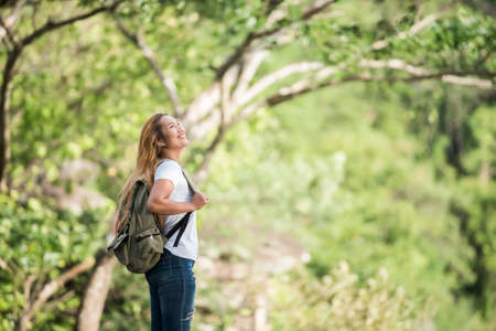 Young tourist woman with backpack enjoy nature standing on top of the mountain.の写真素材