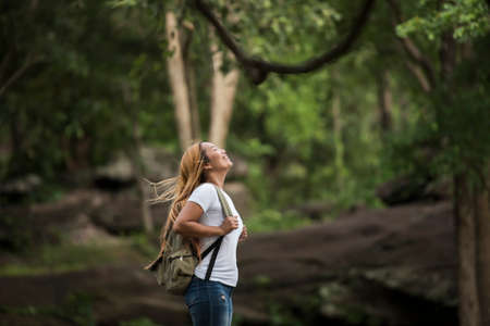 Young tourist woman with backpack enjoy nature standing on top of the mountain.の写真素材