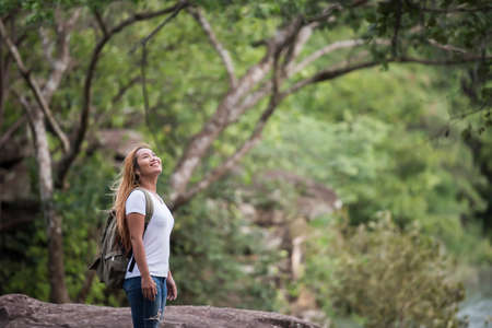 Young tourist woman with backpack enjoy nature standing on top of the mountain.の写真素材