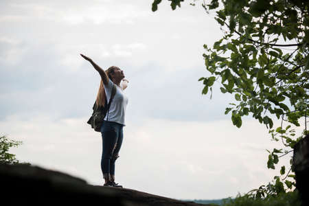 Tourist girl with arms happy with nature near the river. Travel concept.の写真素材