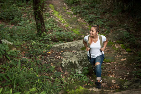 Close up of young backpacker walking through the forest happy with nature. Travel concept.の写真素材