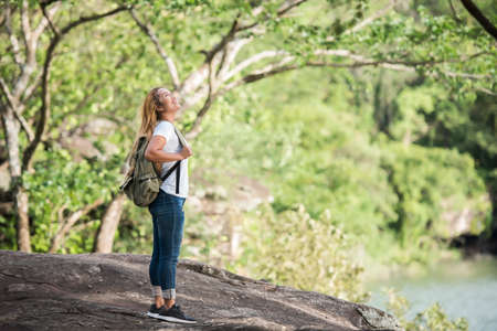Young tourist woman with backpack enjoy nature standing on top of the mountain.の写真素材