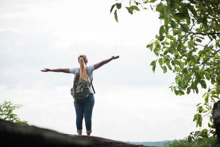 Tourist girl with arms happy with nature near the river. Travel concept.の写真素材