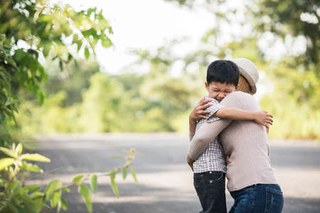 Portrait of mother and son happy cuddle together in the park. Family concept.の写真素材