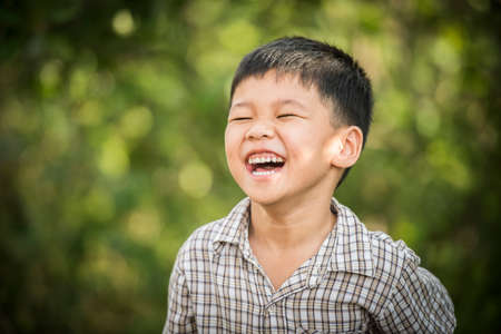 Portrait of happy little boy laughing while he play in the park.の写真素材
