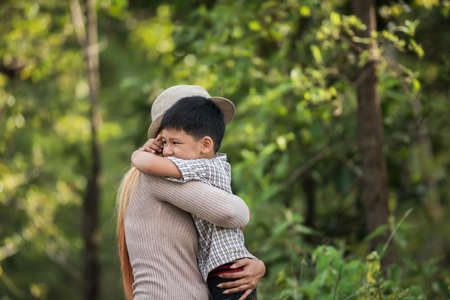 Portrait of mother and son happy cuddle together in the park. Family concept.の写真素材
