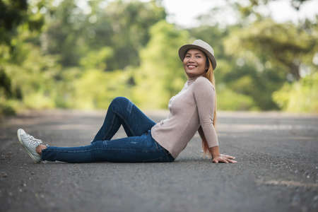 Beautiful Young Woman lying on the road in the park.の写真素材