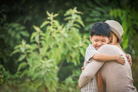 Portrait of mother and son happy cuddle together in the park. Family concept.の写真素材