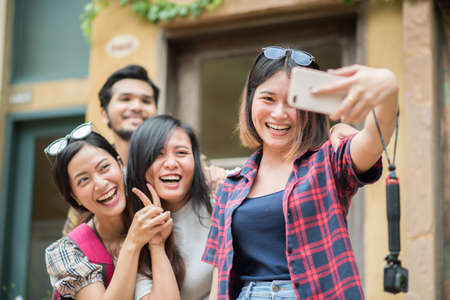 Group of friends taking selfie in a urban street having good fun together.の写真素材