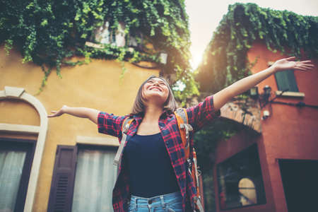 Happy young woman enjoy travel raising her hands in urban. Woman lifestyle concept.の写真素材