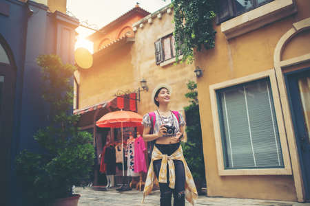 Portrait of young hipster woman backpack traveling taking photo in urban. Happy and enjoy with holiday.の写真素材