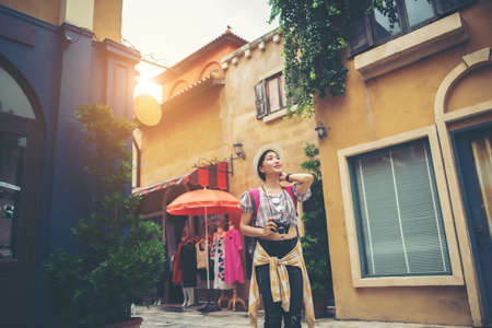 Portrait of young hipster woman backpack traveling taking photo in urban. Happy and enjoy with holiday.の写真素材