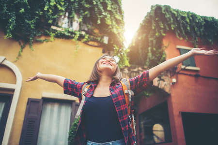 Happy young woman enjoy travel raising her hands in urban. Woman lifestyle concept.の写真素材