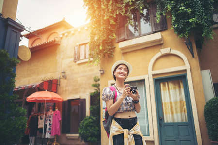 Portrait of young hipster woman backpack traveling taking photo in urban. Happy and enjoy with holiday.の写真素材