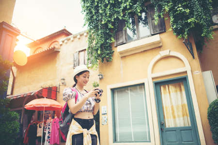Portrait of young hipster woman backpack traveling taking photo in urban. Happy and enjoy with holiday.の写真素材