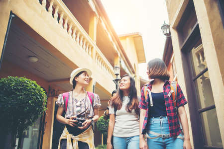 Group of happy young friends having fun walking in urban street. Friendship travel concept.の写真素材