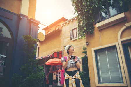 Portrait of young hipster woman backpack traveling taking photo in urban. Happy and enjoy with holiday.の写真素材
