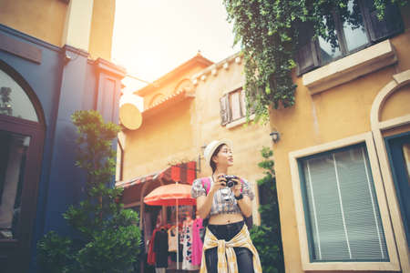 Portrait of young hipster woman backpack traveling taking photo in urban. Happy and enjoy with holiday.の写真素材