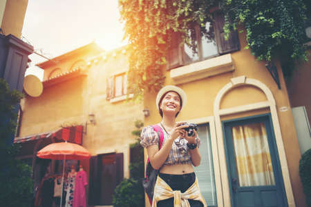 Portrait of young hipster woman backpack traveling taking photo in urban. Happy and enjoy with holiday.の写真素材