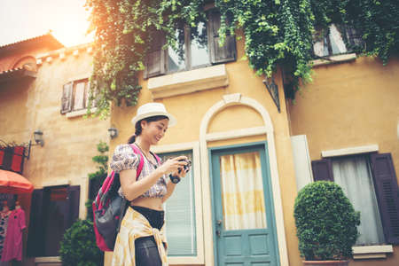 Portrait of young hipster woman backpack traveling taking photo in urban. Happy and enjoy with holiday.の写真素材