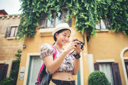 Portrait of young hipster woman backpack traveling taking photo in urban. Happy and enjoy with holiday.の写真素材